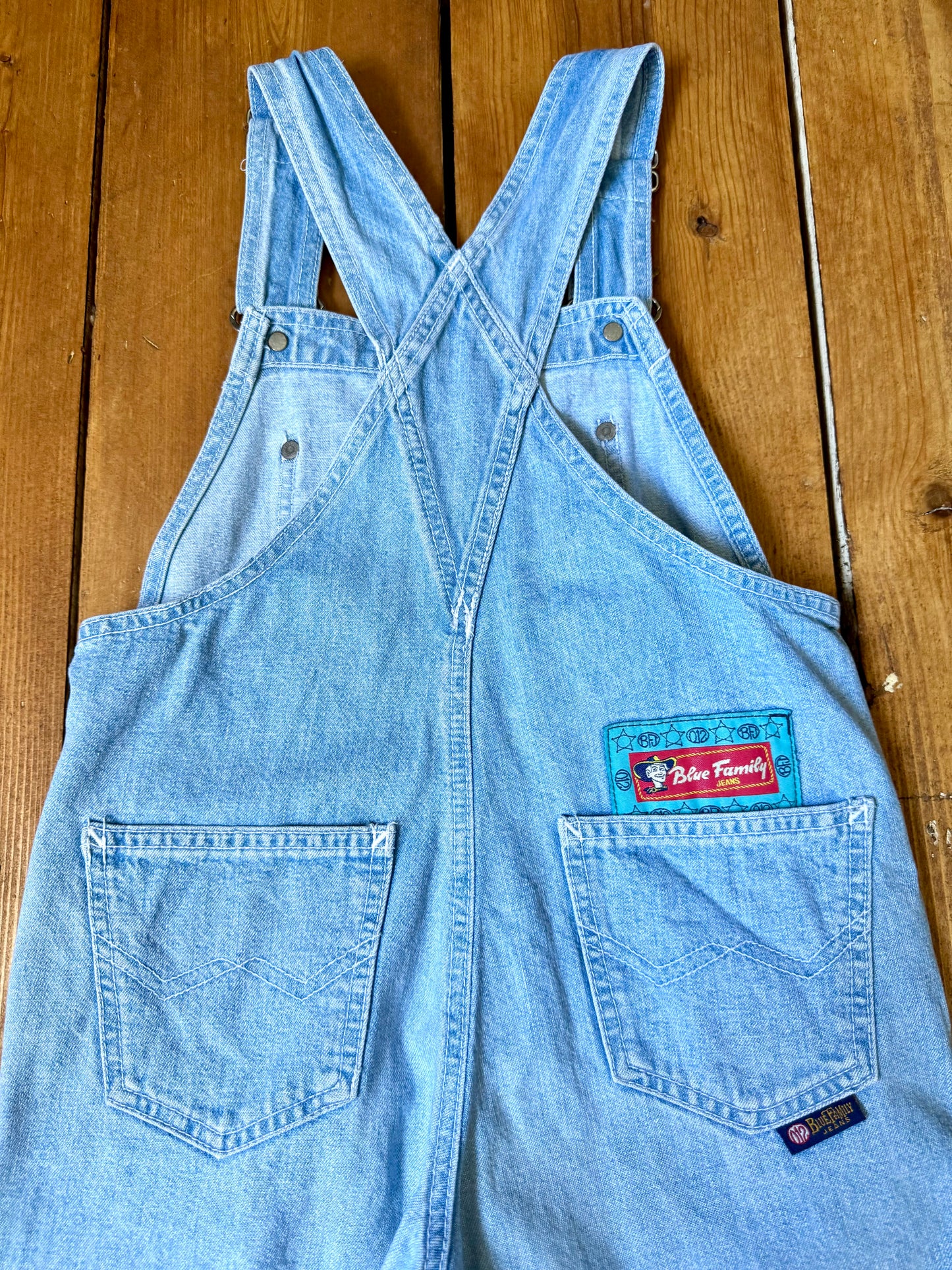 Authentic 90s Blue Family denim short dungarees with adjustable straps, embroidered branding and classic light wash denim. Perfect vintage summer style. Handpicked for Bee Tiny kids vintage. Vintage 90s shortalls.