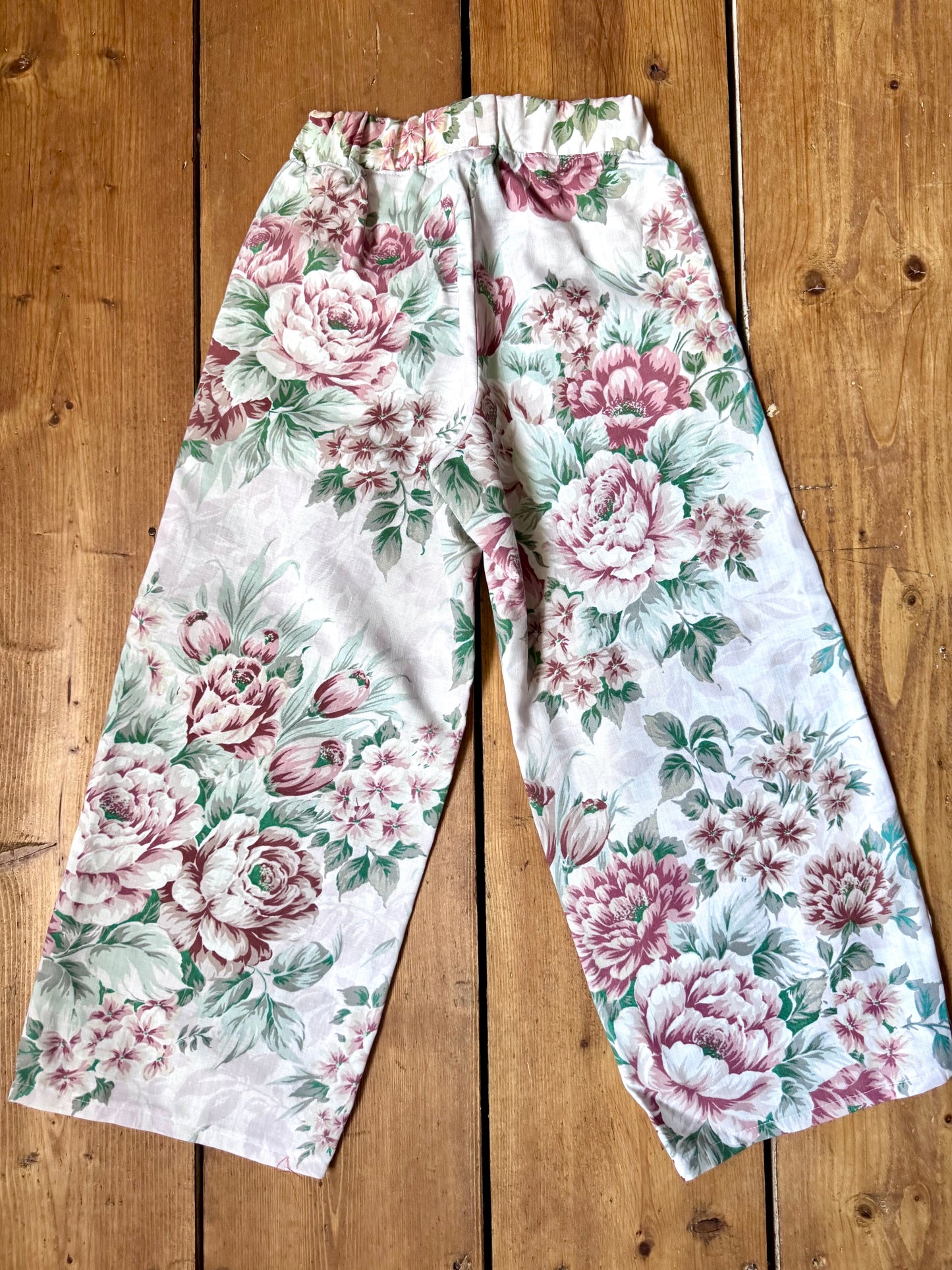 Handmade vintage floral children's set featuring wide-leg trousers and a matching pixie bonnet. One-of-a-kind, sustainably made from rescued fabric. Handmade for Bee Tiny kids vintage.