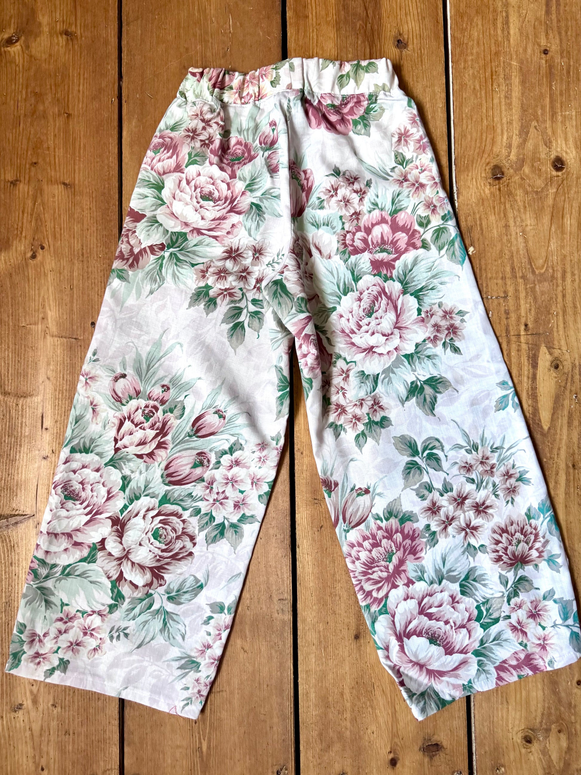 Handmade vintage floral children's set featuring wide-leg trousers and a matching pixie bonnet. One-of-a-kind, sustainably made from rescued fabric. Handmade for Bee Tiny kids vintage.