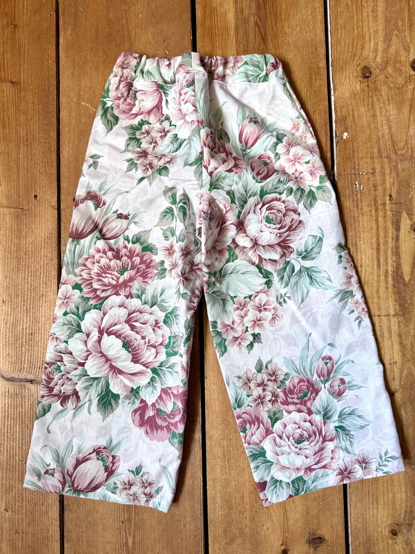 Handmade vintage floral children's set featuring wide-leg trousers and a matching pixie bonnet. One-of-a-kind, sustainably made from rescued fabric. Handmade for Bee Tiny kids vintage.
