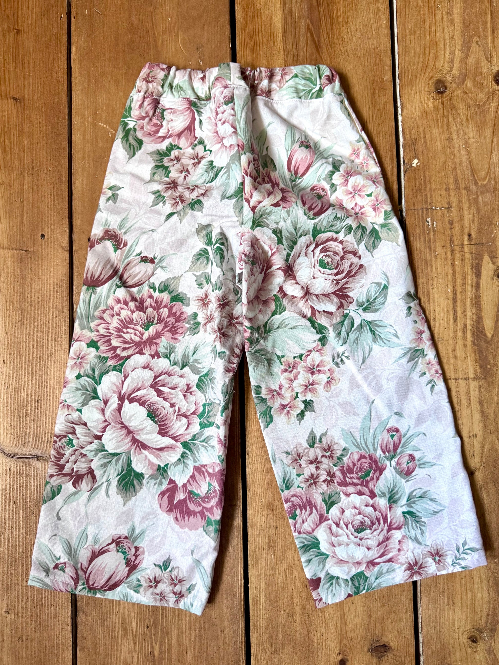 Handmade vintage floral children's set featuring wide-leg trousers and a matching pixie bonnet. One-of-a-kind, sustainably made from rescued fabric. Handmade for Bee Tiny kids vintage.