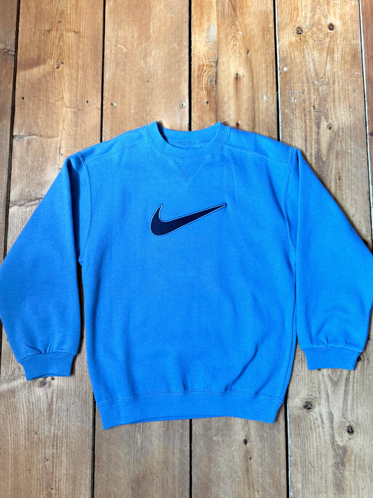 Vintage Nike blue sweatshirt with an embroidered Swoosh, soft fleece lining and original swing tag. A timeless unisex kidswear staple, handpicked by Bee Tiny kids vintage.