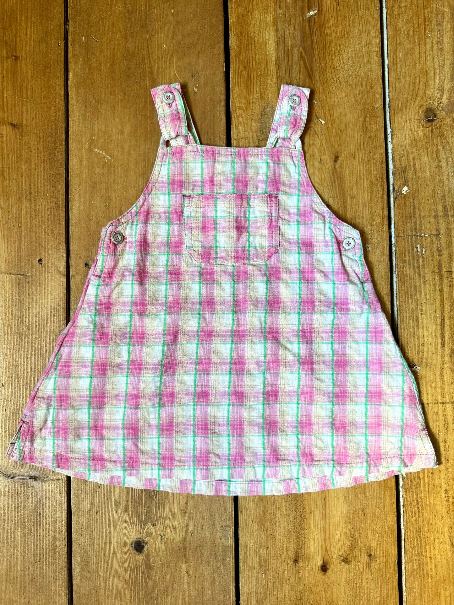 Vintage baby dress bundle featuring an Adams denim pinafore and pink gingham summer dress. Two timeless outfits for babies aged 6–9 months. Handpicked for Bee Tiny kids vintage.