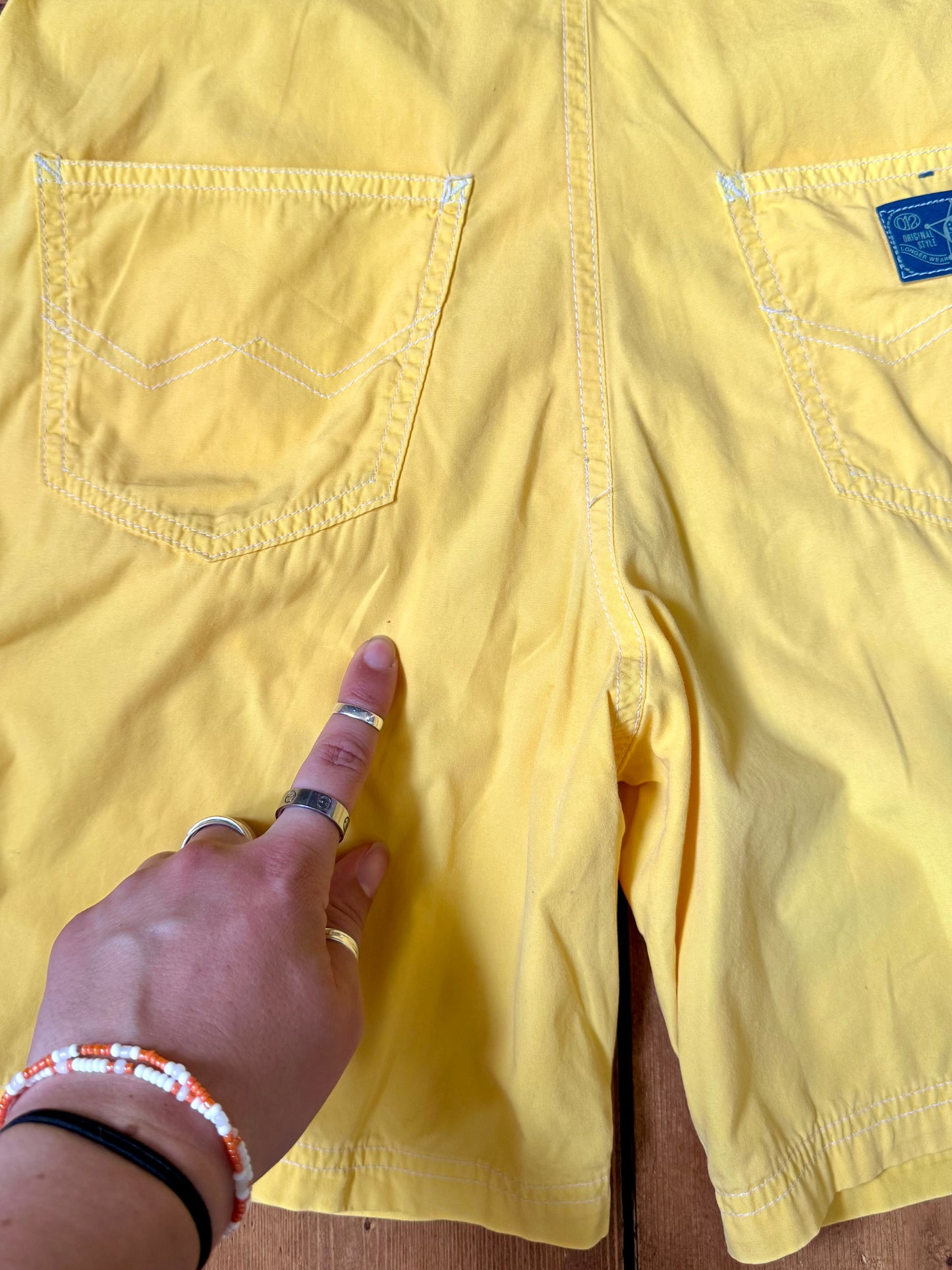 Authentic 90s United Colors of Benetton yellow cotton dungaree shorts, with adjustable straps. Lightweight vintage summer dungarees for kids age 10 years. Handpicked for Bee Tiny.