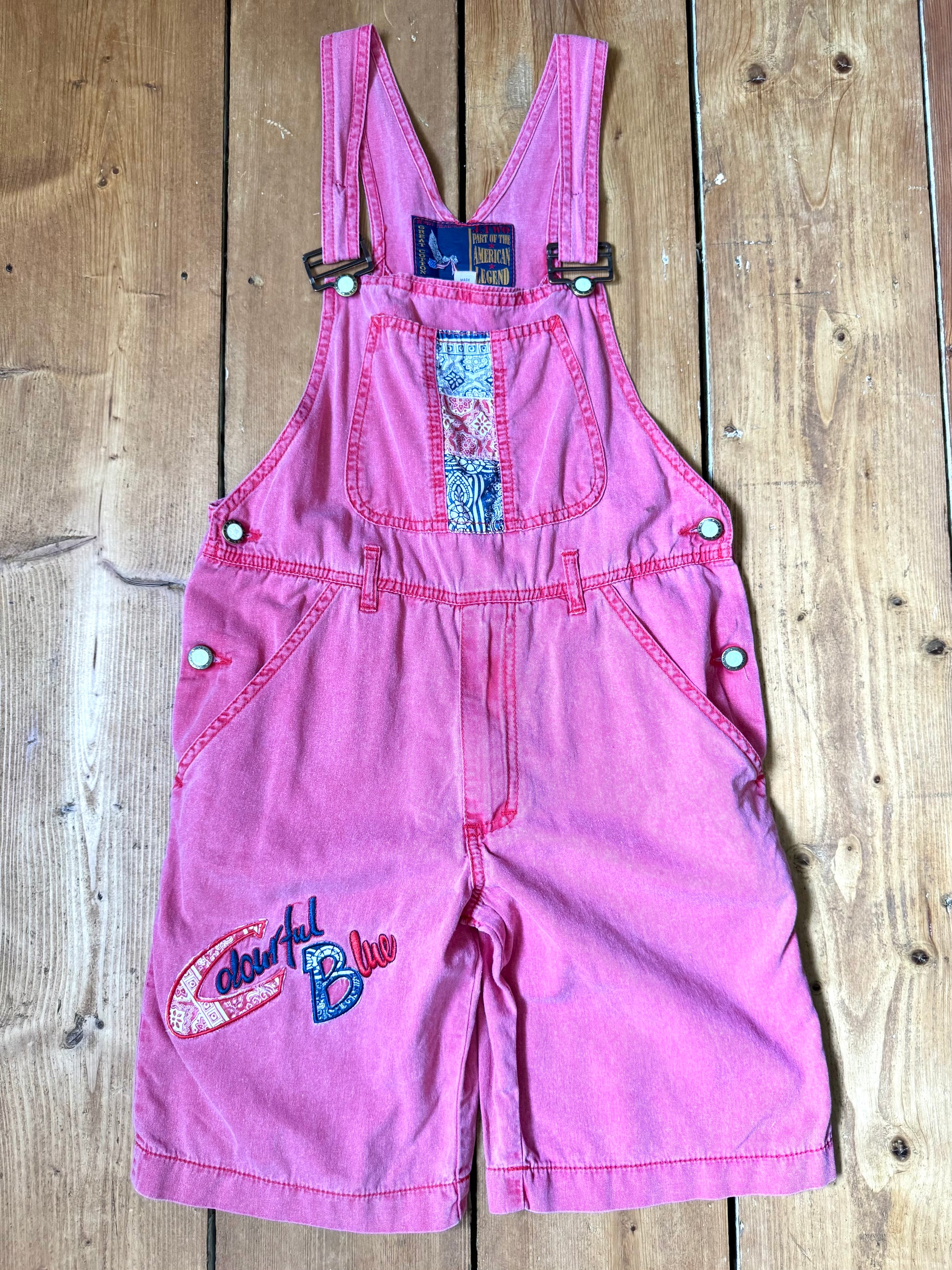 Vintage 90s pink dungaree shorts with paisley patchwork detailing. A colourful summer vintage favourite for kids. Handpicked for Bee Tiny kids vintage. 