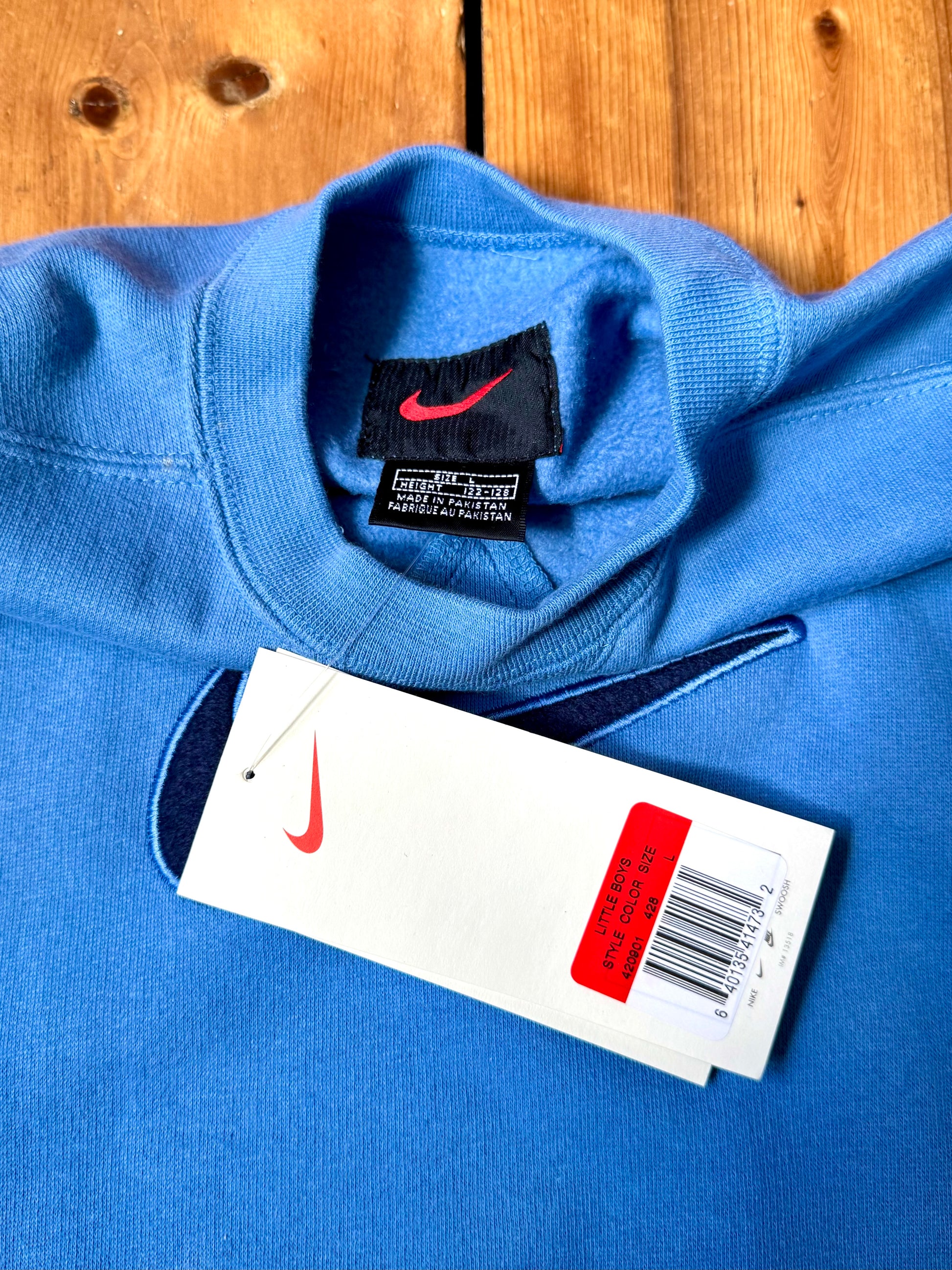 Vintage Nike blue sweatshirt with an embroidered Swoosh, soft fleece lining and original swing tag. A timeless unisex kidswear staple, handpicked by Bee Tiny kids vintage.