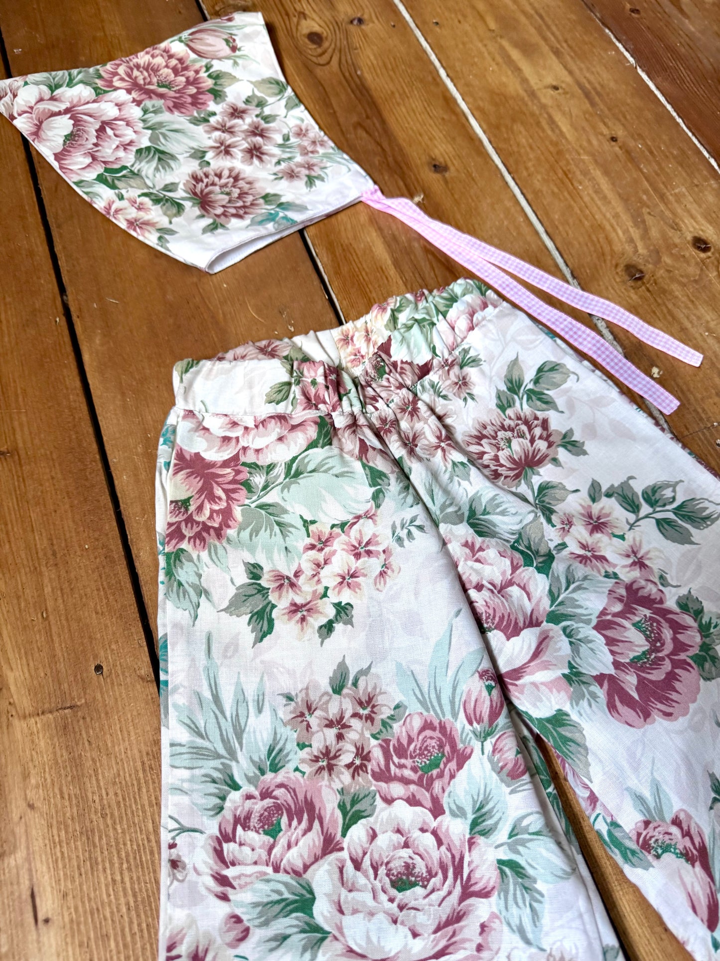 Handmade vintage floral children's set featuring wide-leg trousers and a matching pixie bonnet. One-of-a-kind, sustainably made from rescued fabric. Handmade for Bee Tiny kids vintage.