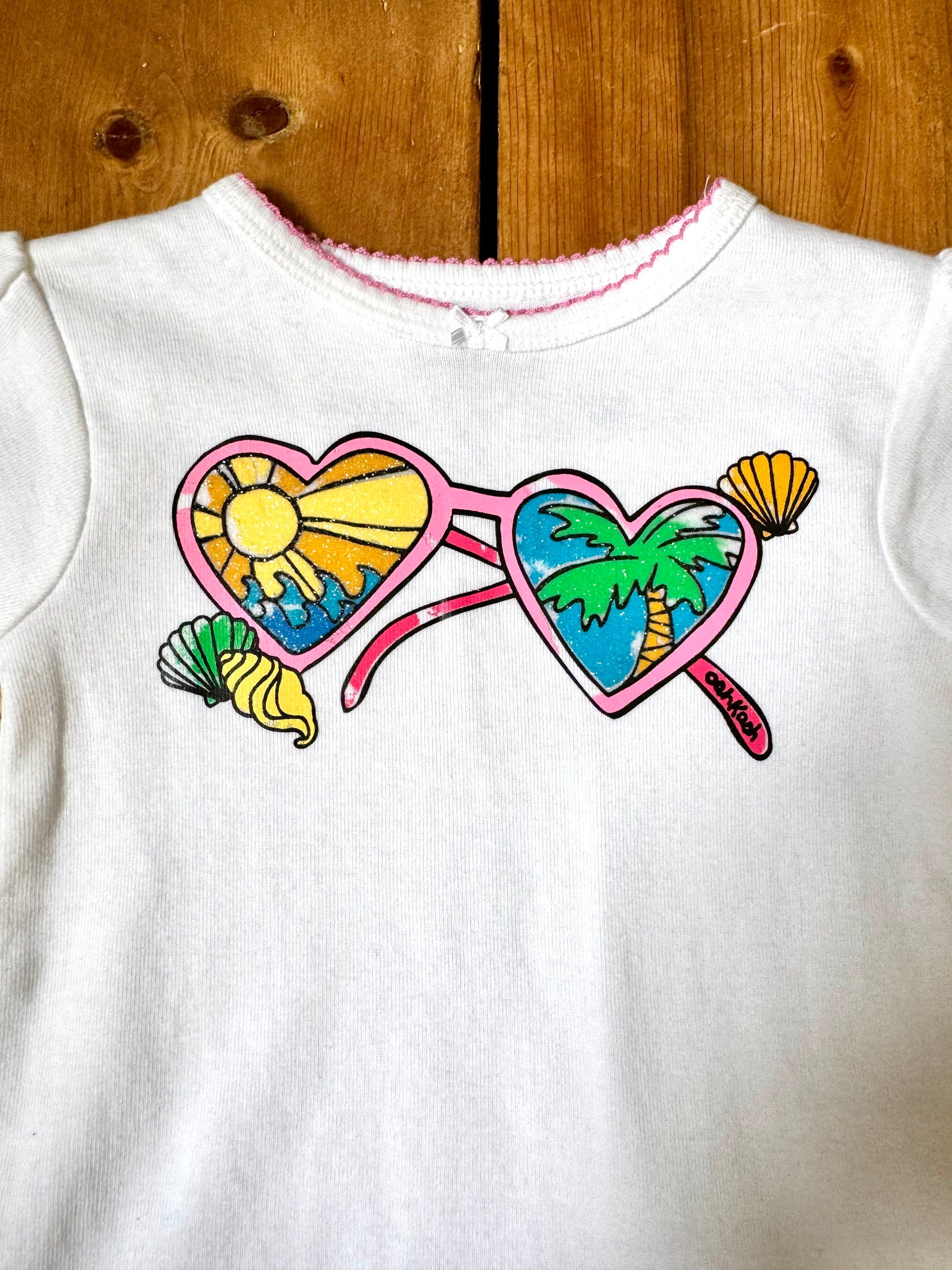 Deadstock OshKosh Y2K T-shirt with tropical heart sunglasses graphic. Authentic vintage kidswear with original tags. Handpicked for Bee Tiny kids vintage.
