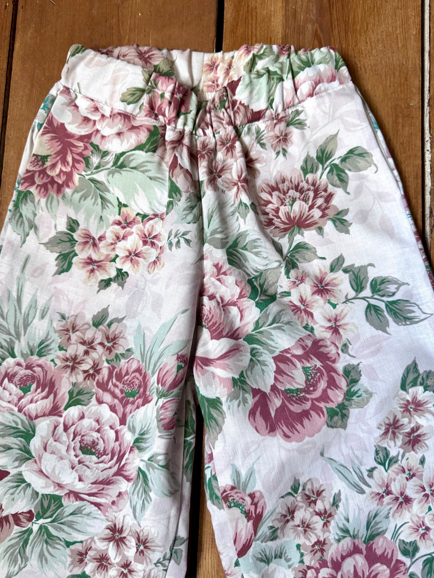 Handmade vintage floral children's set featuring wide-leg trousers and a matching pixie bonnet. One-of-a-kind, sustainably made from rescued fabric. Handmade for Bee Tiny kids vintage.