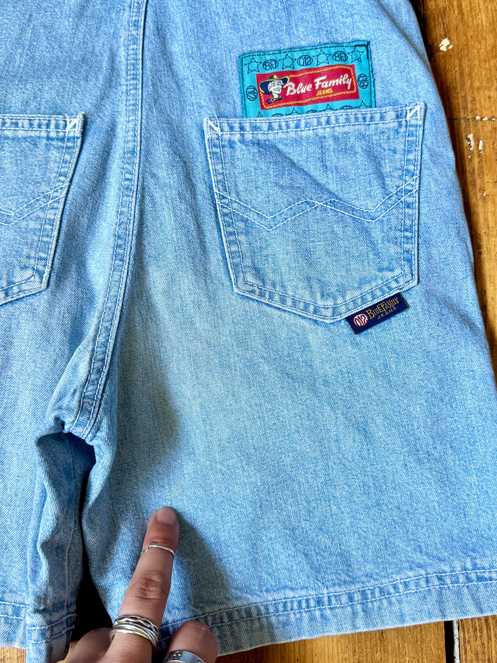 Authentic 90s Blue Family denim short dungarees with adjustable straps, embroidered branding and classic light wash denim. Perfect vintage summer style. Handpicked for Bee Tiny kids vintage. Vintage 90s shortalls.