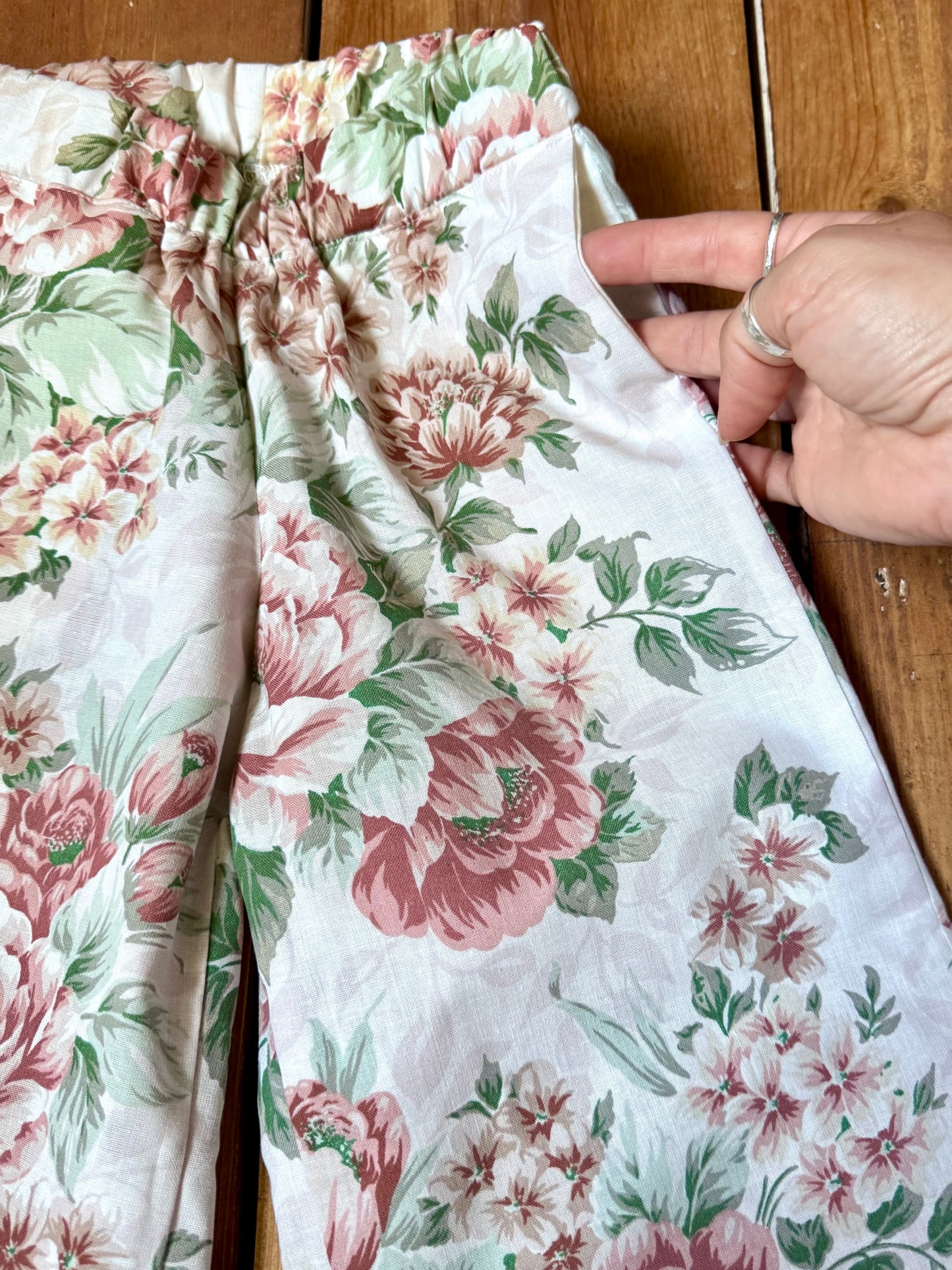 Handmade vintage floral children's set featuring wide-leg trousers and a matching pixie bonnet. One-of-a-kind, sustainably made from rescued fabric. Handmade for Bee Tiny kids vintage.
