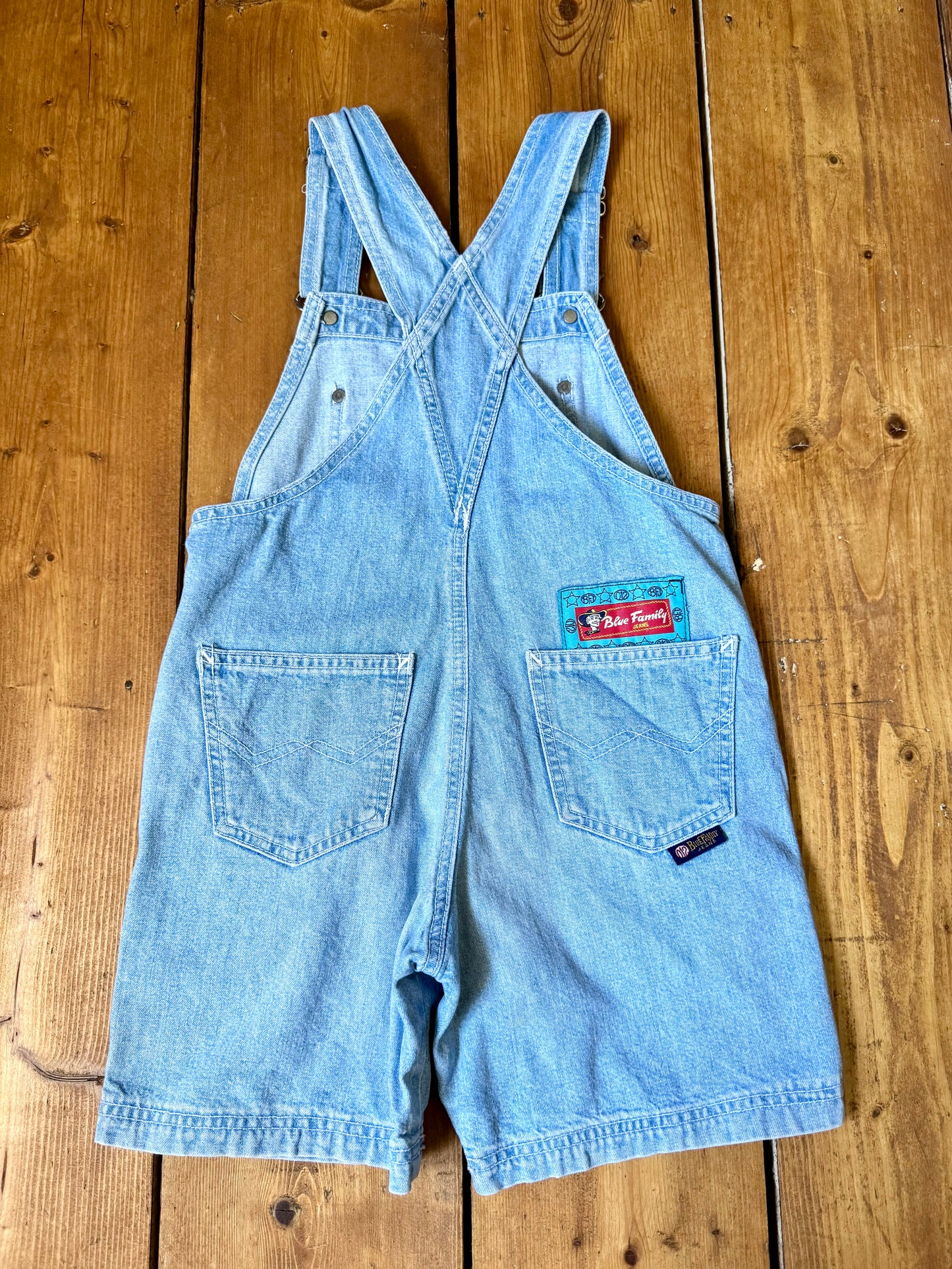 Authentic 90s Blue Family denim short dungarees with adjustable straps, embroidered branding and classic light wash denim. Perfect vintage summer style. Handpicked for Bee Tiny kids vintage. Vintage 90s shortalls.