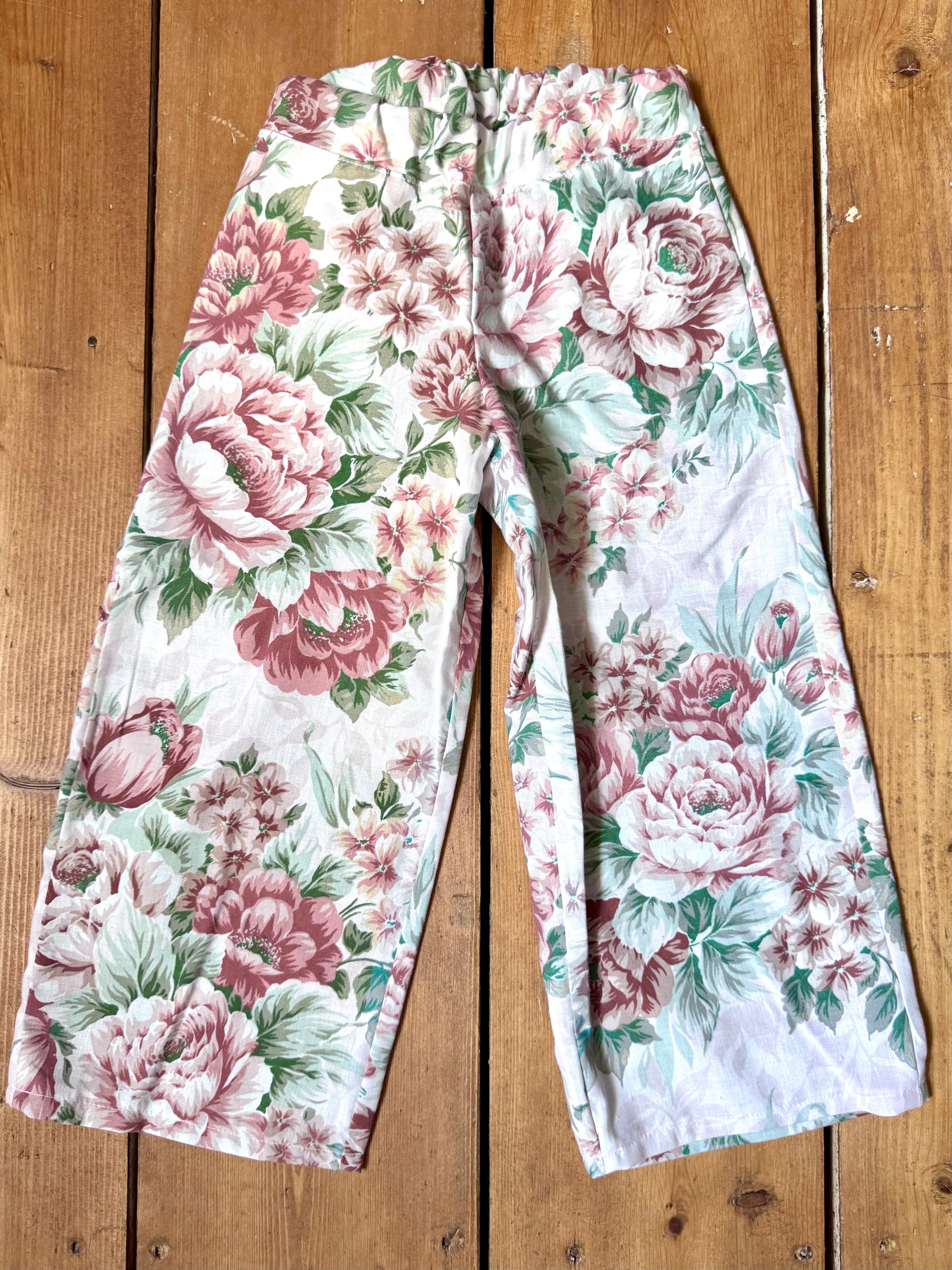 Handmade vintage floral children's set featuring wide-leg trousers and a matching pixie bonnet. One-of-a-kind, sustainably made from rescued fabric. Handmade for Bee Tiny kids vintage.