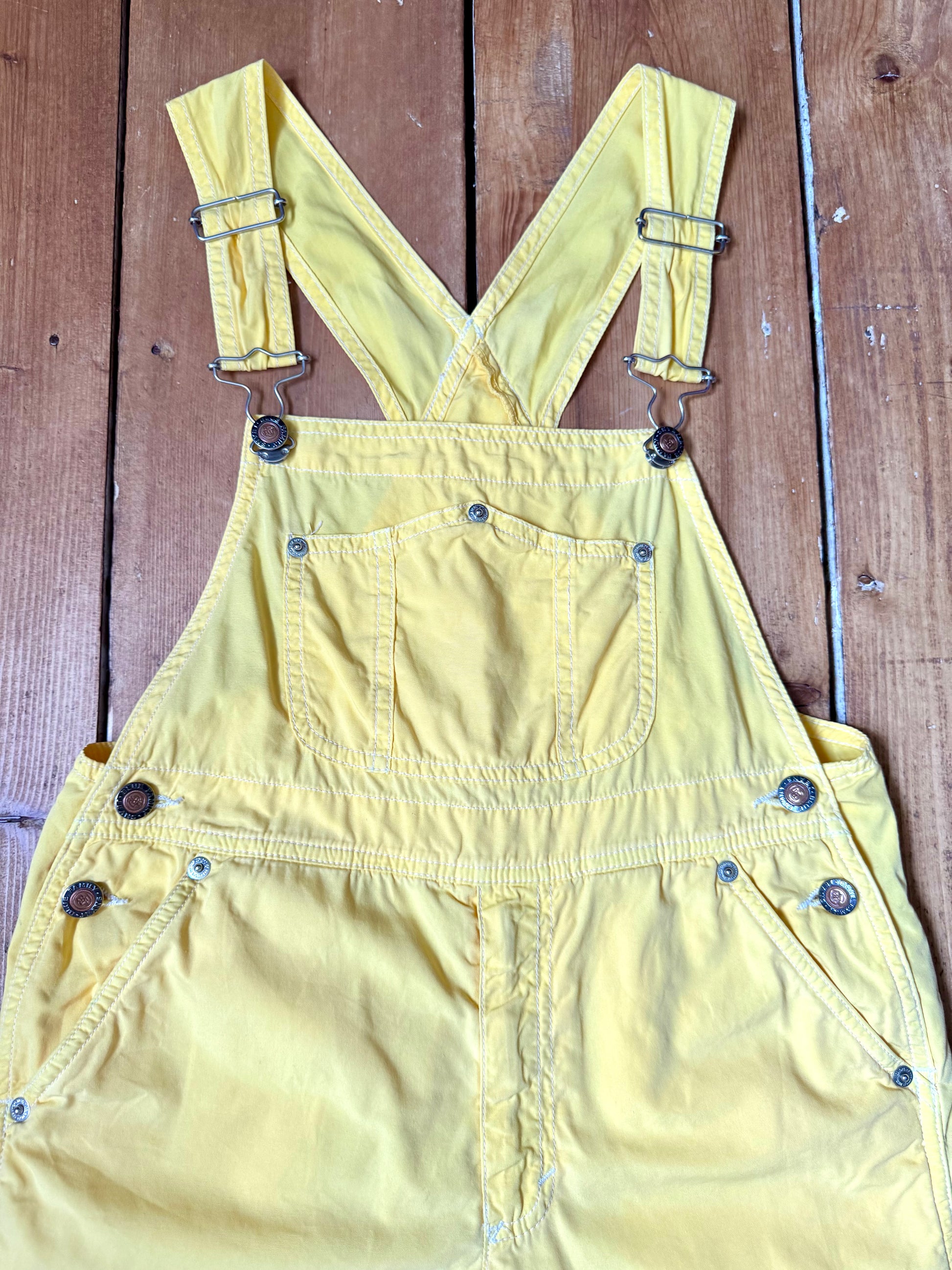 Authentic 90s United Colors of Benetton yellow cotton dungaree shorts, with adjustable straps. Lightweight vintage summer dungarees for kids age 10 years. Handpicked for Bee Tiny.