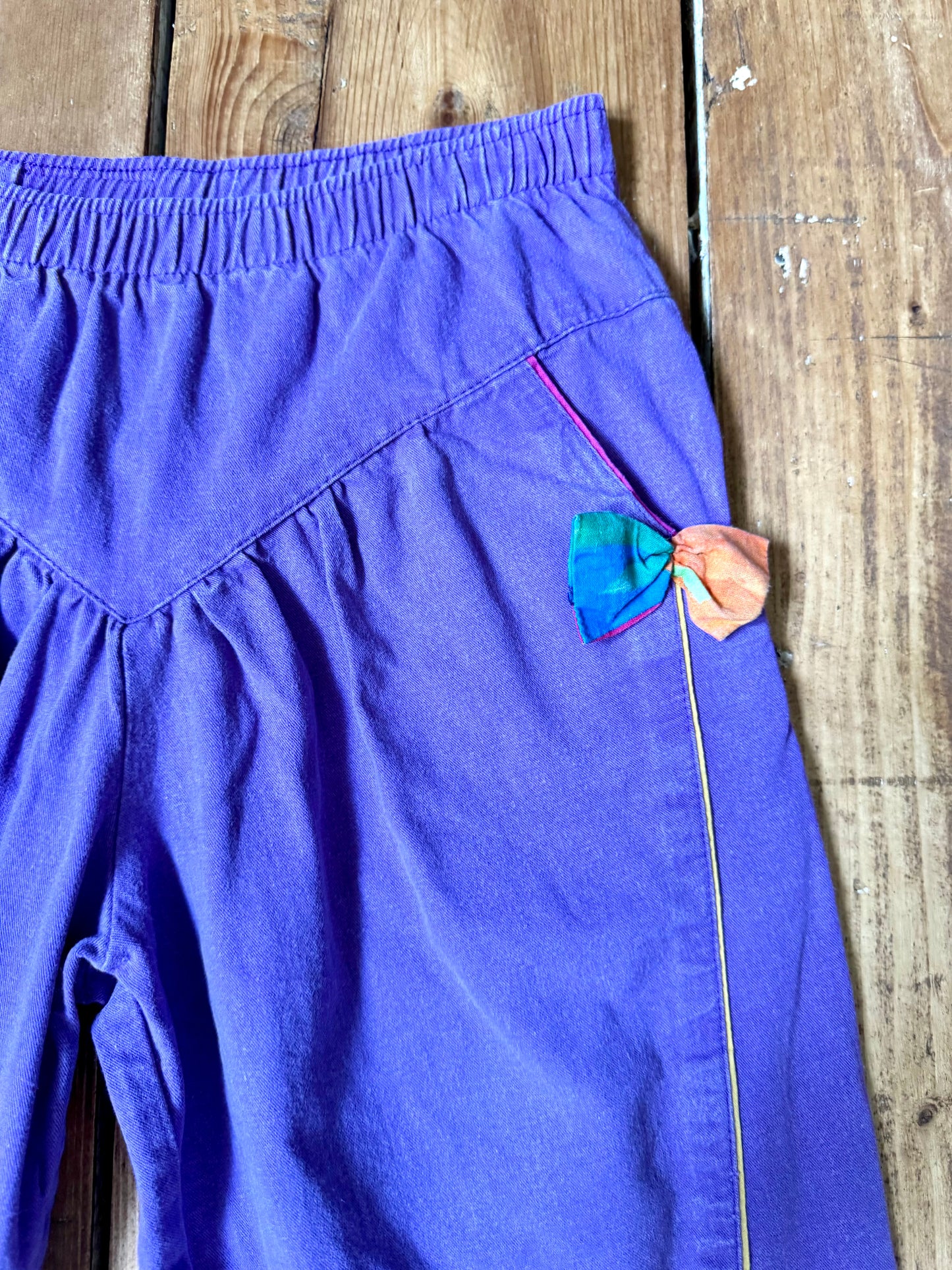 Vintage 80s purple children's trousers with rainbow details from the late 80s/early 90s. Bright, playful and handpicked for Bee Tiny kids vintage.