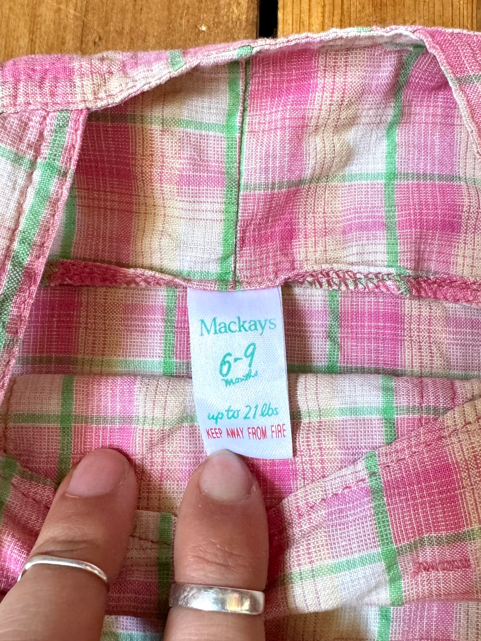 Vintage baby dress bundle featuring an Adams denim pinafore and pink gingham summer dress. Two timeless outfits for babies aged 6–9 months. Handpicked for Bee Tiny kids vintage.