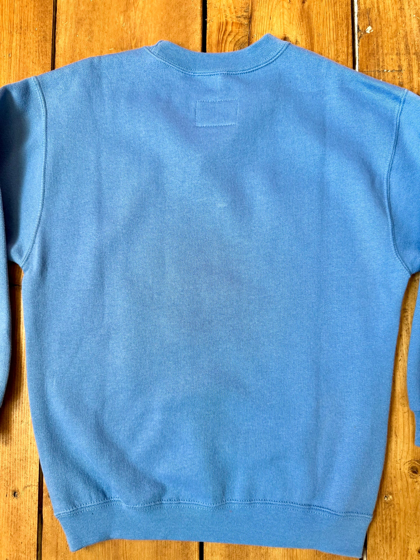 Vintage Nike blue sweatshirt with an embroidered Swoosh, soft fleece lining and original swing tag. A timeless unisex kidswear staple, handpicked by Bee Tiny kids vintage.