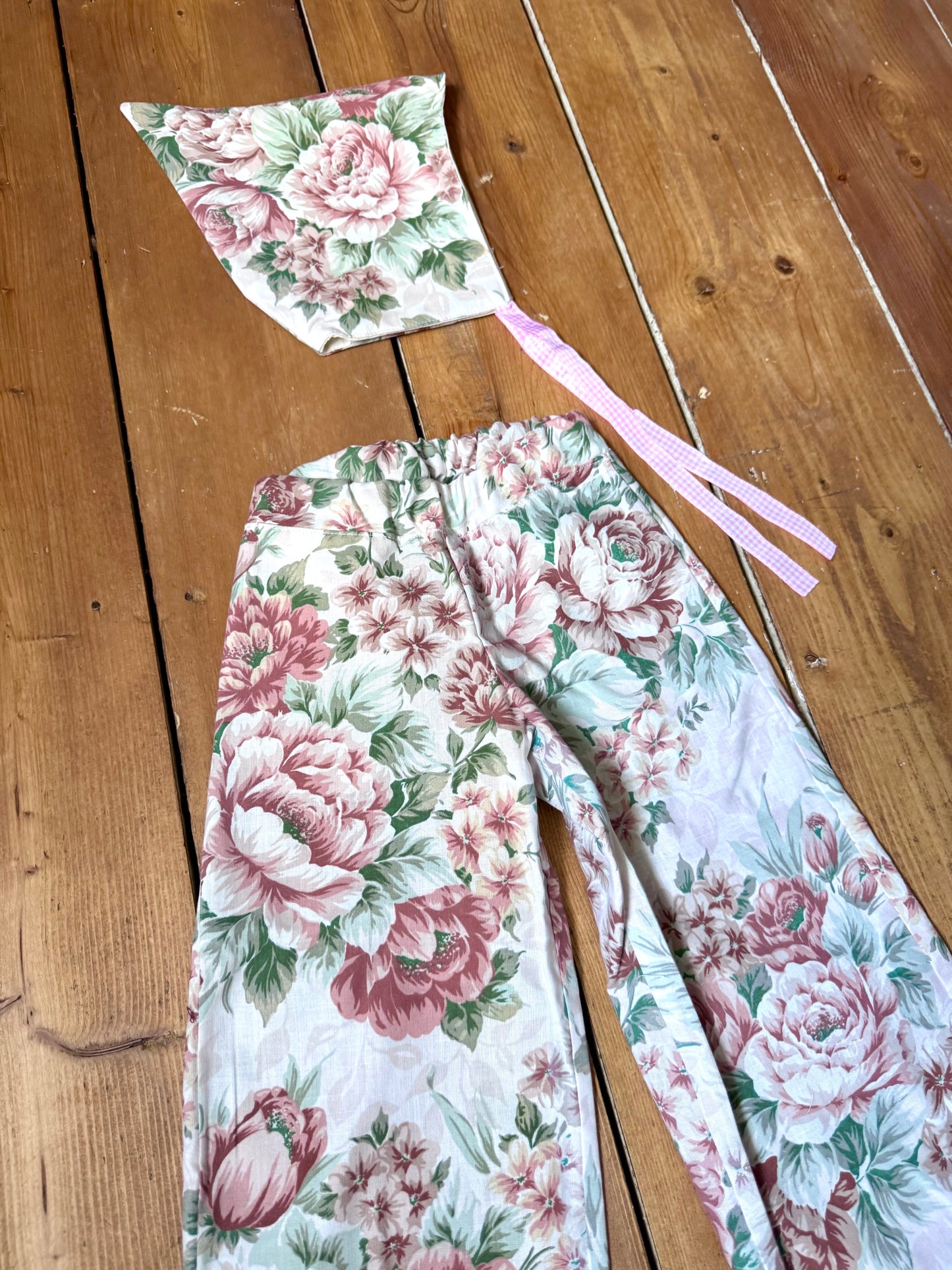 Handmade vintage floral children's set featuring wide-leg trousers and a matching pixie bonnet. One-of-a-kind, sustainably made from rescued fabric. Handmade for Bee Tiny kids vintage.