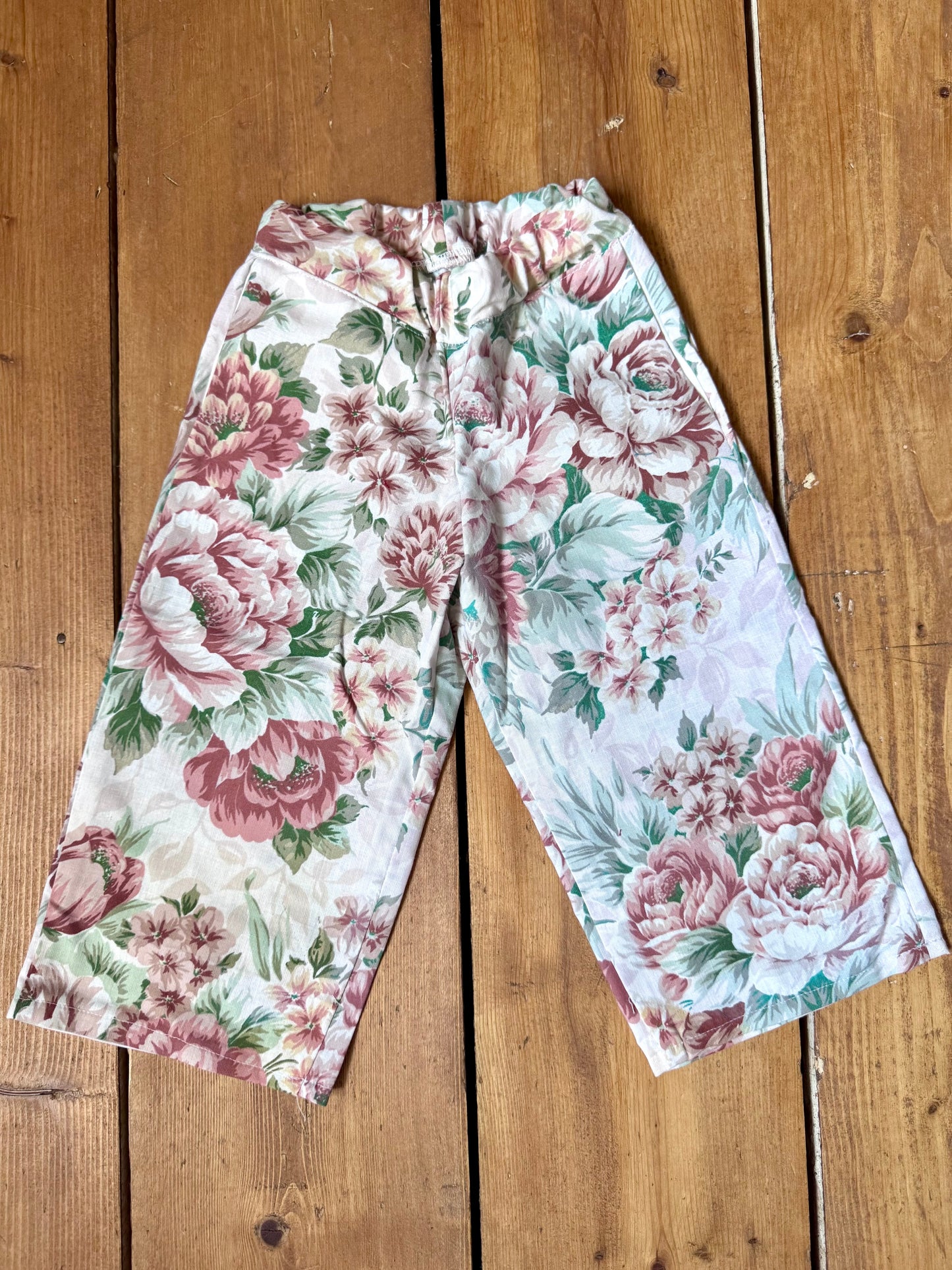 Handmade vintage floral children's set featuring wide-leg trousers and a matching pixie bonnet. One-of-a-kind, sustainably made from rescued fabric. Handmade for Bee Tiny kids vintage.