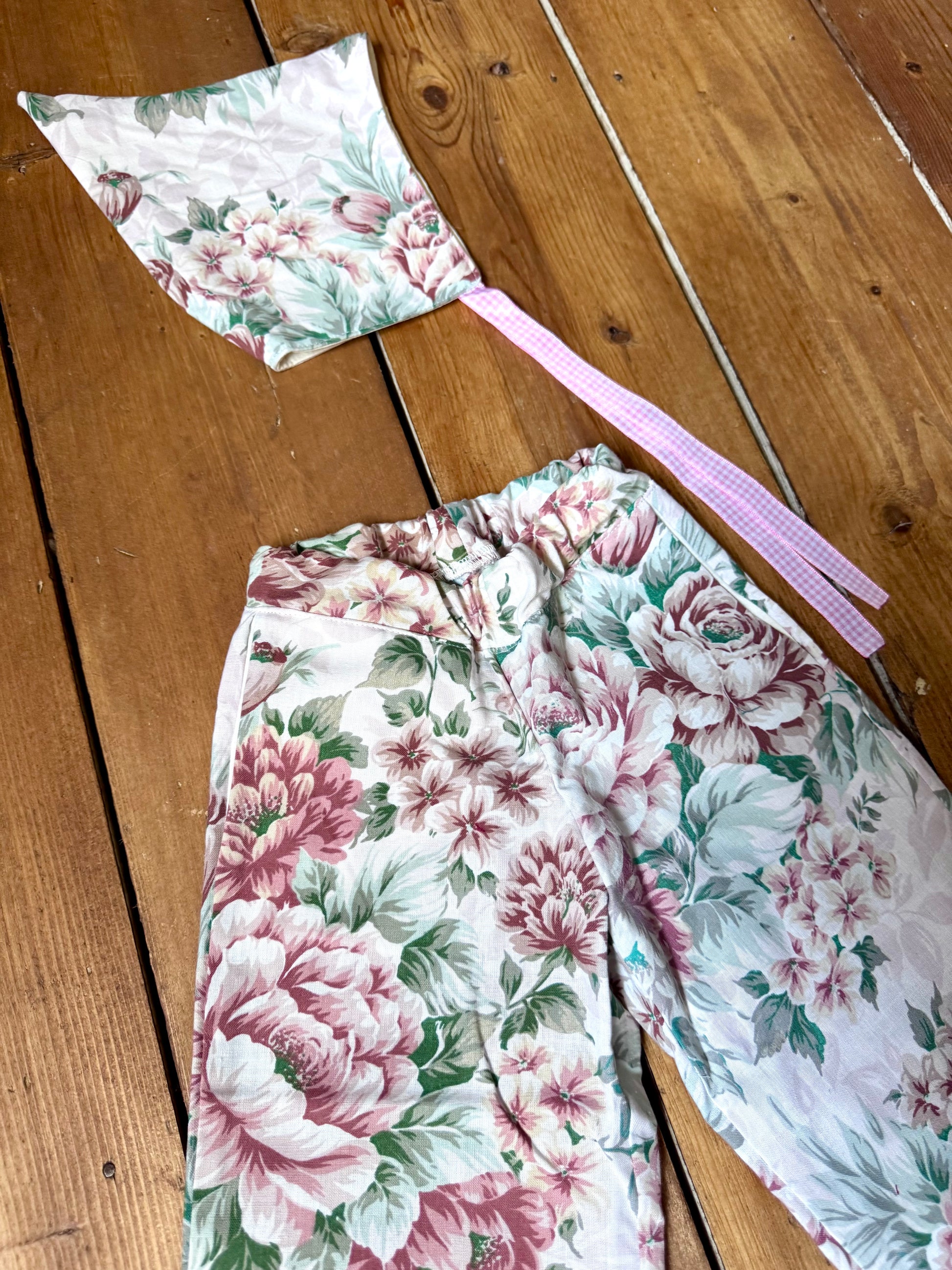 Handmade vintage floral children's set featuring wide-leg trousers and a matching pixie bonnet. One-of-a-kind, sustainably made from rescued fabric. Handmade for Bee Tiny kids vintage.