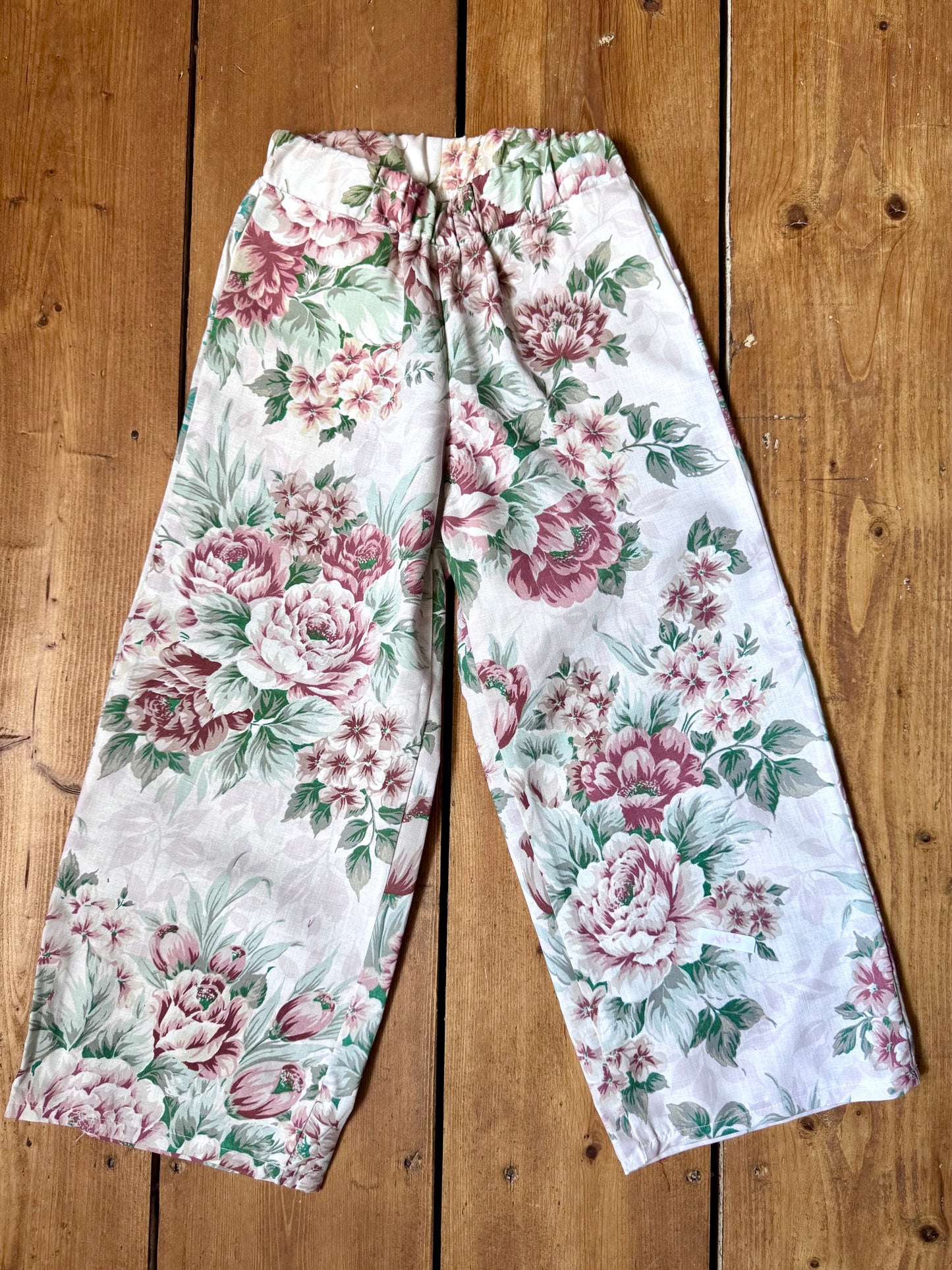 Handmade vintage floral children's set featuring wide-leg trousers and a matching pixie bonnet. One-of-a-kind, sustainably made from rescued fabric. Handmade for Bee Tiny kids vintage.