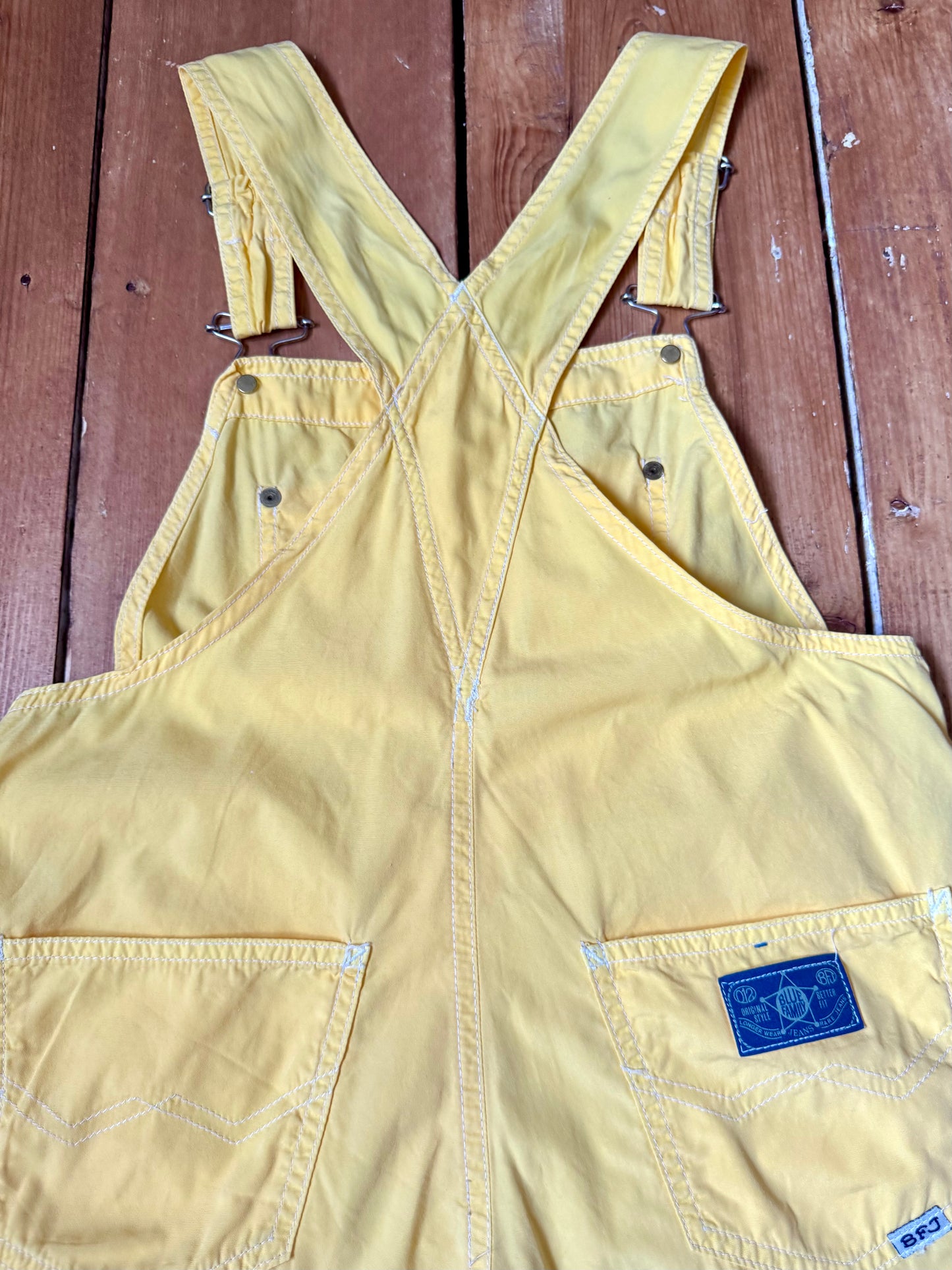 Authentic 90s United Colors of Benetton yellow cotton dungaree shorts, with adjustable straps. Lightweight vintage summer dungarees for kids age 10 years. Handpicked for Bee Tiny.