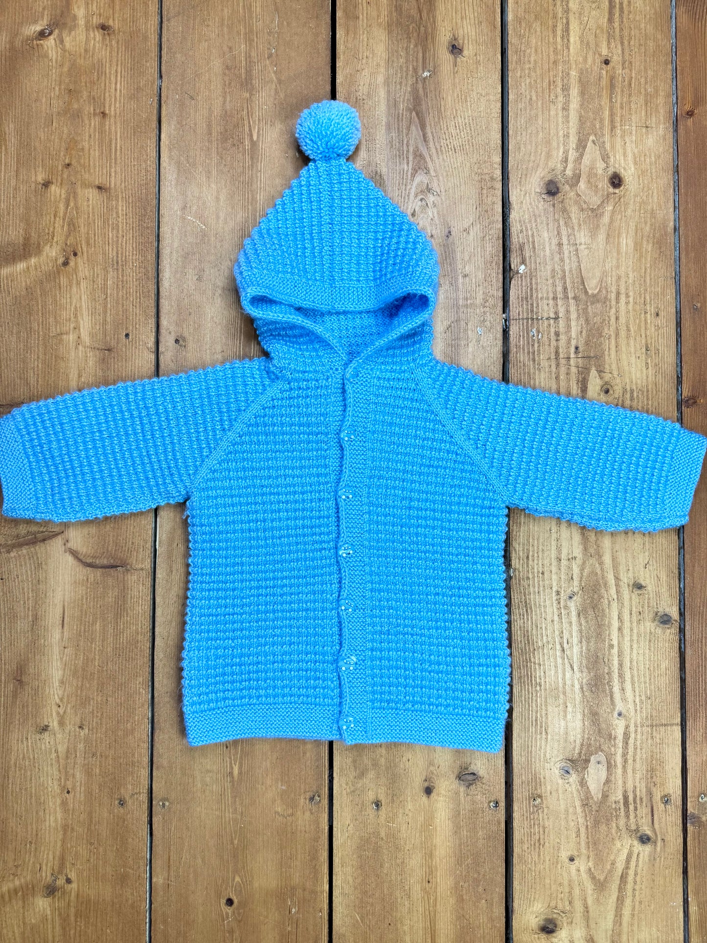 Blue knitted baby cardigan with pom pom hood. Handpicked for Bee Tiny kids vintage.