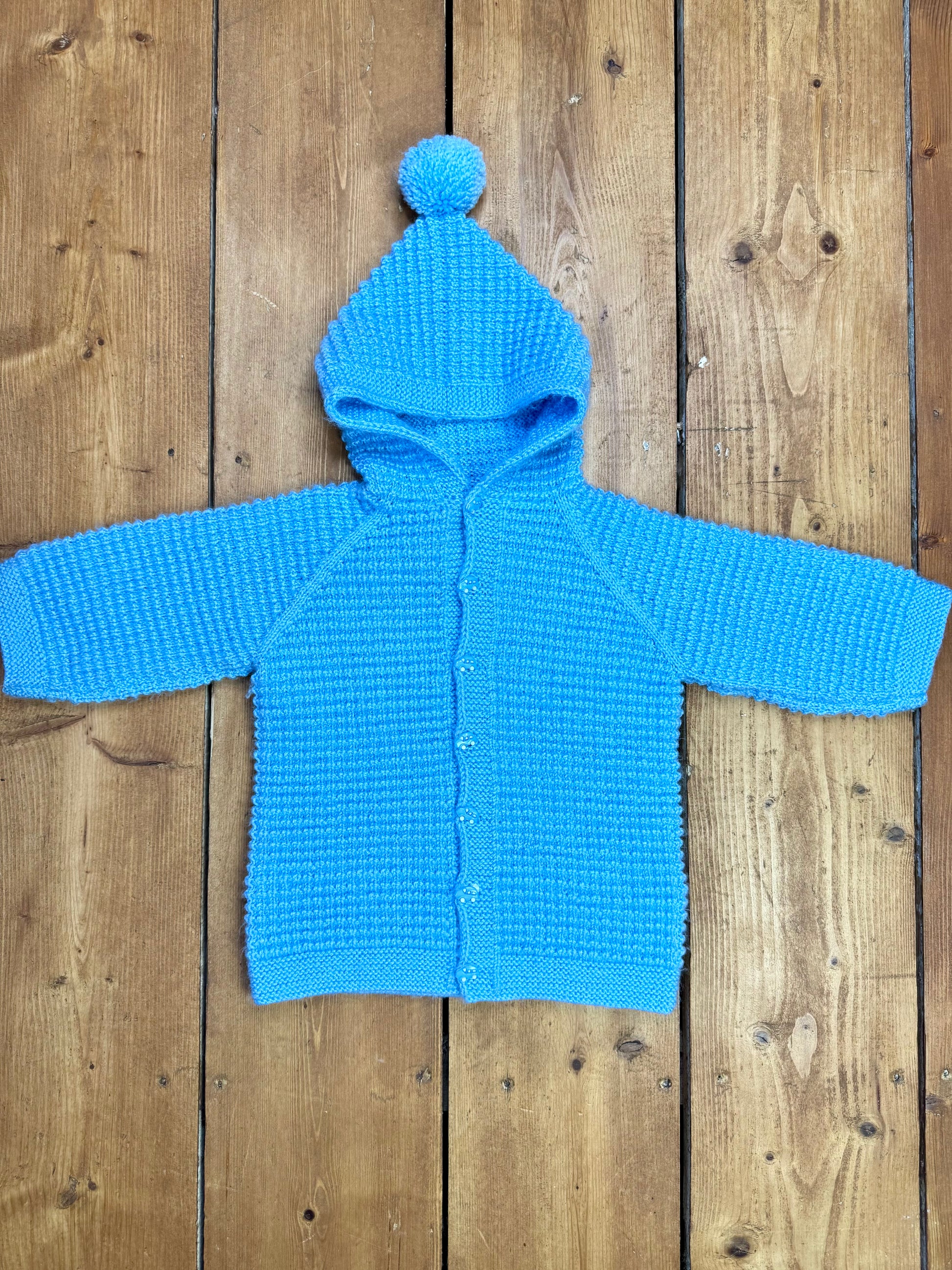 Blue knitted baby cardigan with pom pom hood. Handpicked for Bee Tiny kids vintage.